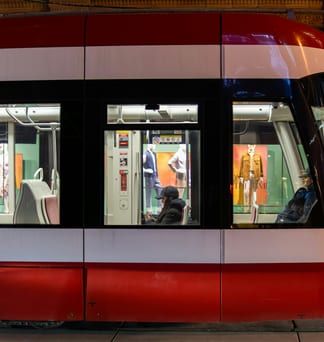 Passengers seen through the windows of a red-and-white Toronto streetcar.